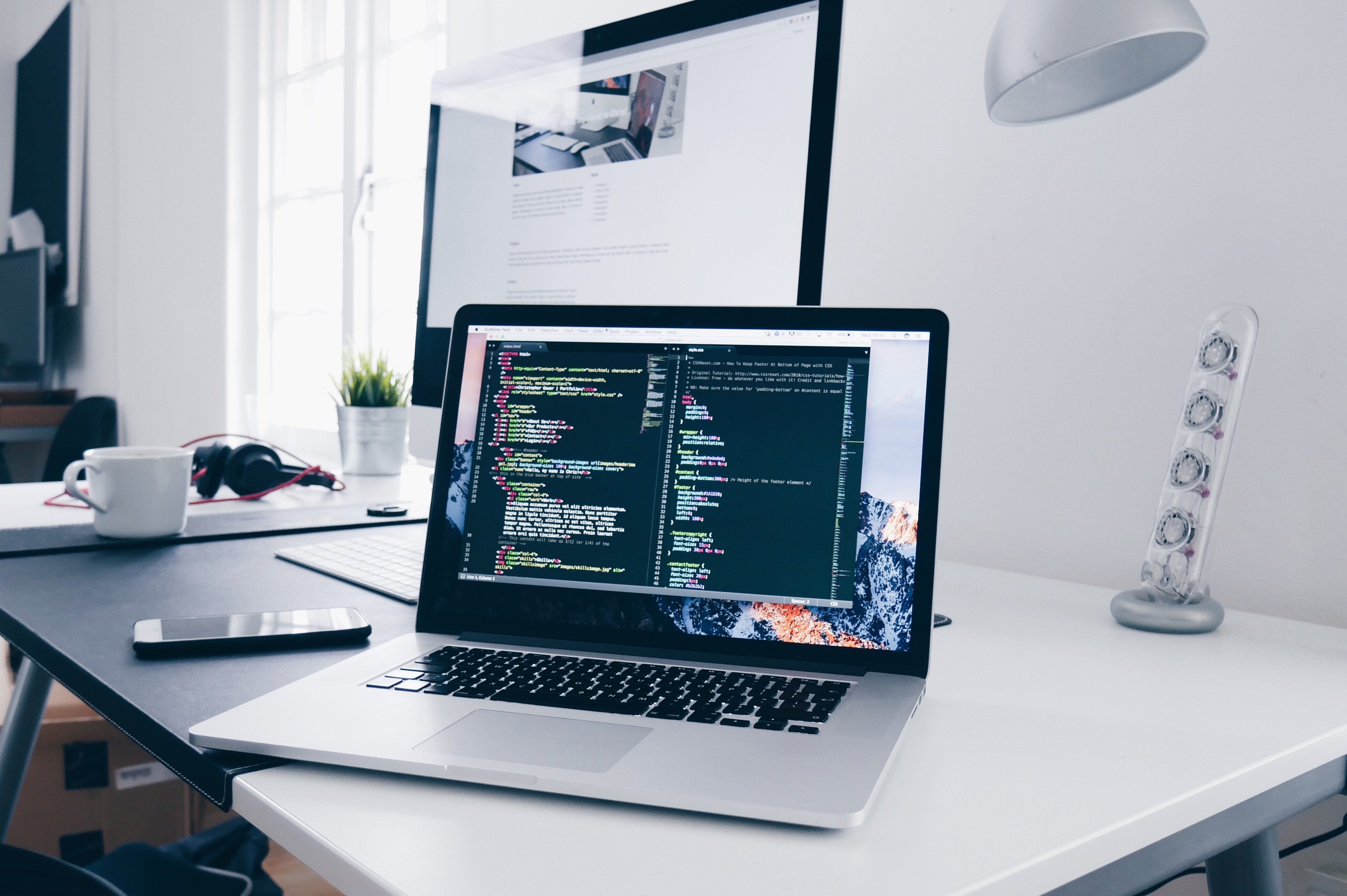 Laptop mit Code-Editor auf einem Schreibtisch